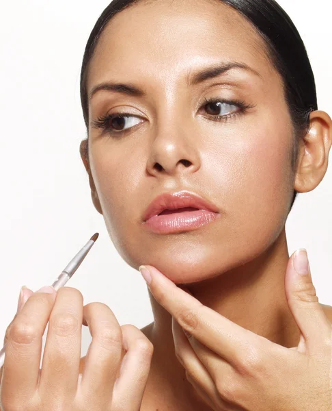 Latin woman applying makeup and lipstick — Stock Photo, Image