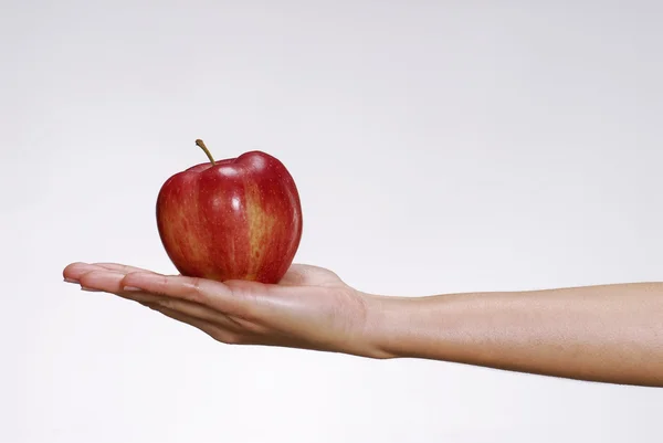 Mão feminina segurando uma maçã vermelha . — Fotografia de Stock