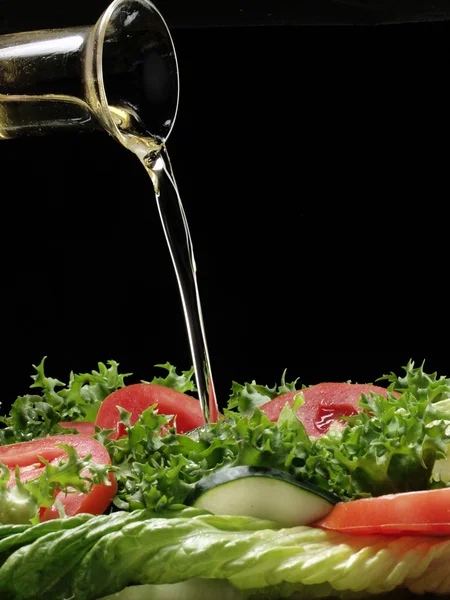 Pouring olive oil and fresh salad. — Stock Photo, Image