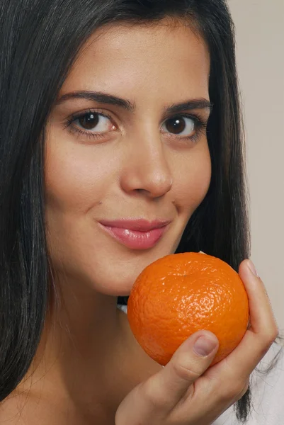 Jovem segurando uma laranja fresca — Fotografia de Stock