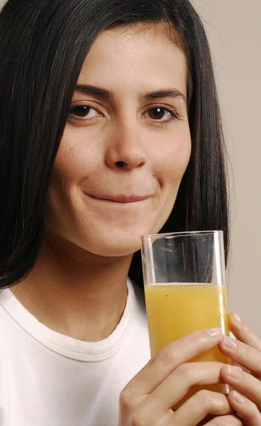 Mujer joven bebiendo jugo de naranja — Foto de Stock