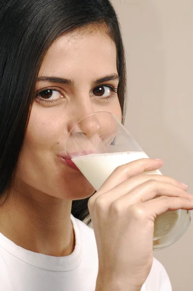 Jonge vrouw die melk drinkt — Stockfoto