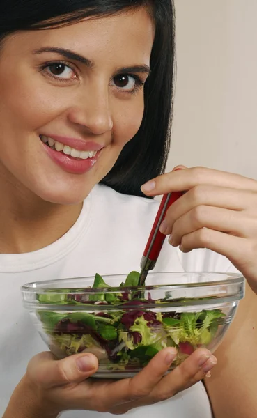 Jeune femme mangeant une salade de légumes frais — Photo