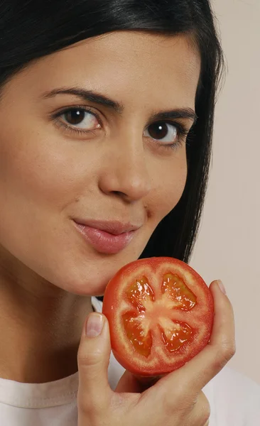 Mujer latina joven comiendo tomate — Foto de Stock