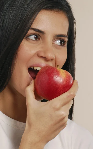 Giovane donna che mangia una mela rossa — Foto Stock