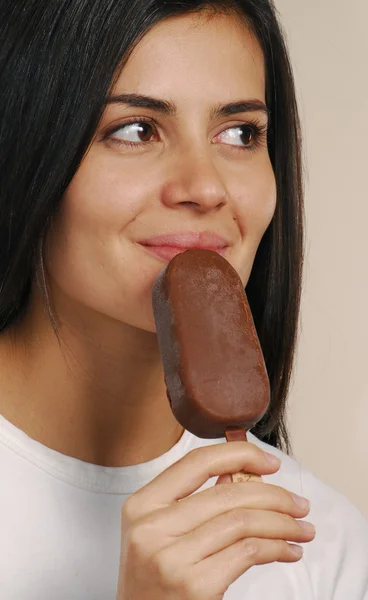 Jovem mulher comendo um sorvete de chocolate — Fotografia de Stock