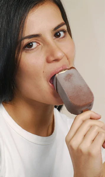 Junge Frau isst ein Schokoladeneis — Stockfoto
