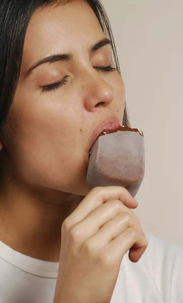 Молодая женщина ест шоколадное мороженое — стоковое фото