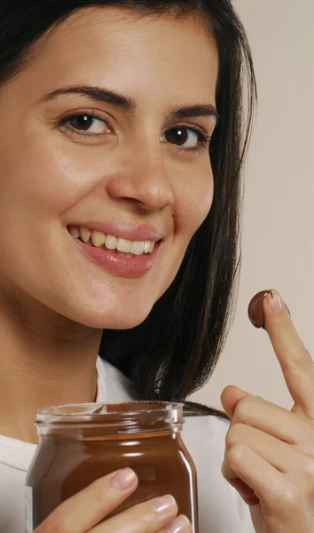 Mujer joven comiendo crema de chocolate —  Fotos de Stock