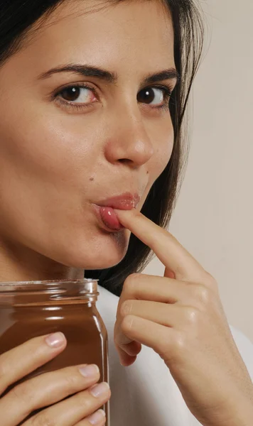 Молодая женщина ест шоколадный крем — стоковое фото