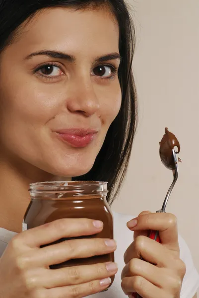 Junge Frau isst Schokoladencreme — Stockfoto