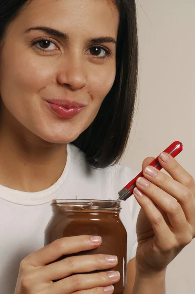 Ung kvinna äta choklad grädde — Stockfoto