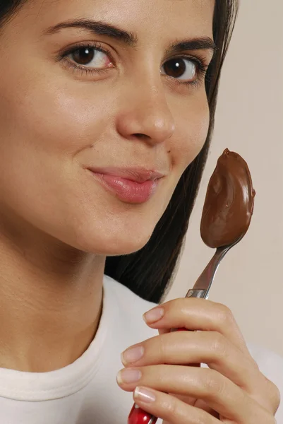 Jovem mulher comer creme de chocolate — Fotografia de Stock