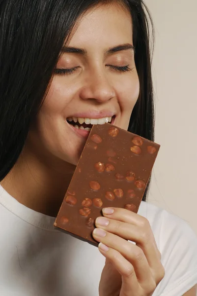 Young woman eating a nuts chocolate — Stock Photo, Image