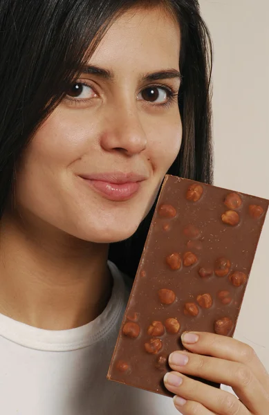 Mujer joven comiendo un chocolate de nueces —  Fotos de Stock