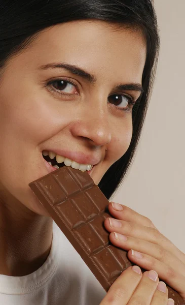 Jovem mulher comendo um chocolate nozes — Fotografia de Stock