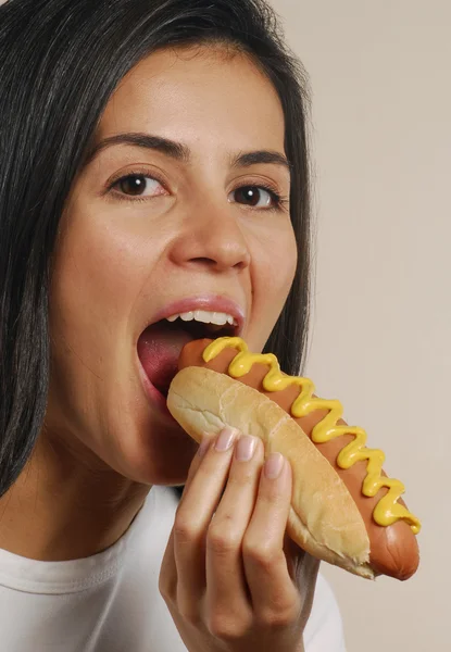 Jovem mulher comendo cachorro quente — Fotografia de Stock