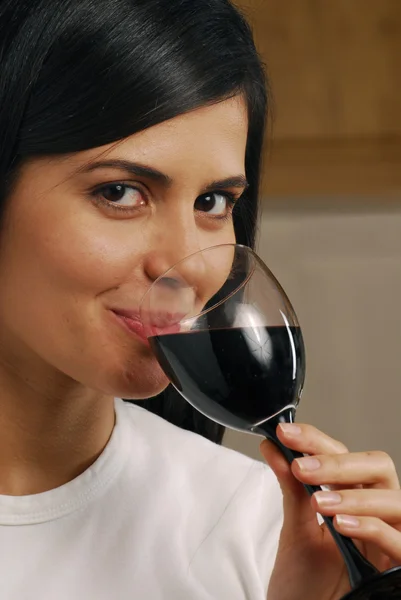 Unga vackra kvinnan dricker rött vin — Stockfoto