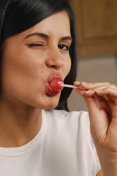Ung kvinna äta lollipop — Stockfoto