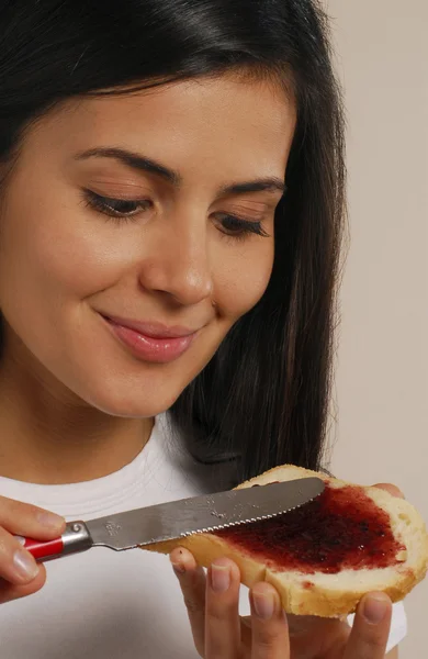 Ung kvinna äta marmelad toast — Stockfoto