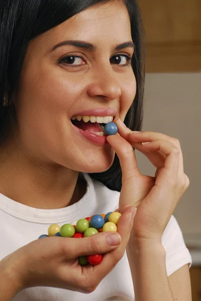 Jovem mulher comendo doces — Fotografia de Stock