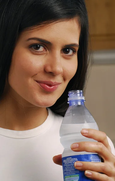 Giovane donna che beve acqua minerale — Foto Stock