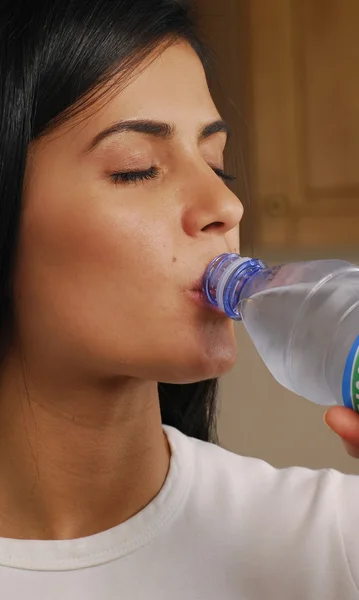 Молодая женщина пьет минеральную воду — стоковое фото