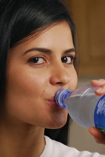 Giovane donna che beve acqua minerale — Foto Stock