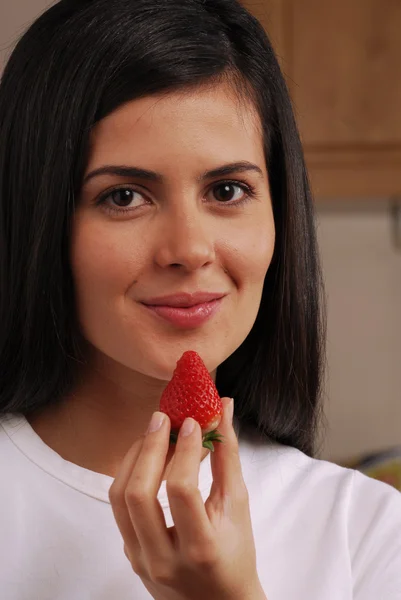 Mladá žena jíst čerstvé jahody — Stock fotografie