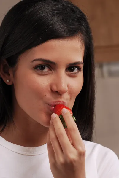 Mladá žena jíst čerstvé jahody — Stock fotografie