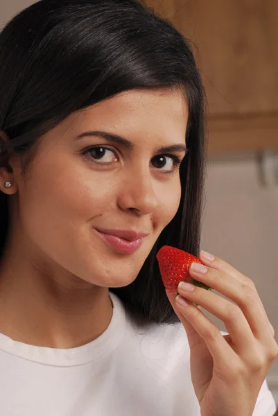 Jeune femme mangeant des fraises fraîches — Photo