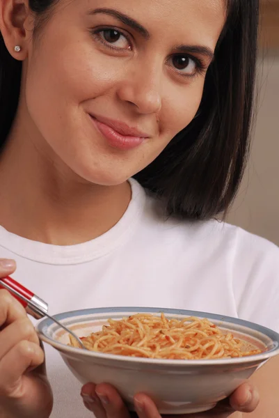 Ung kvinna äta pasta — Stockfoto