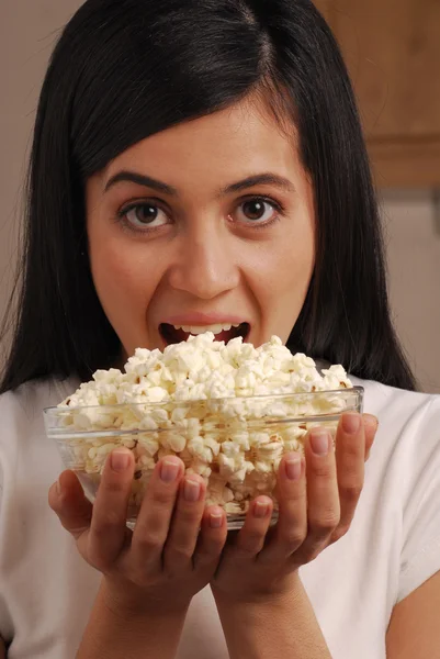 Jovem mulher comendo milho pop — Fotografia de Stock