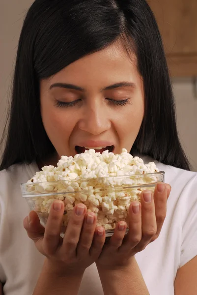 Jovem mulher comendo milho pop — Fotografia de Stock