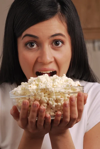 Jovem mulher comendo milho pop — Fotografia de Stock