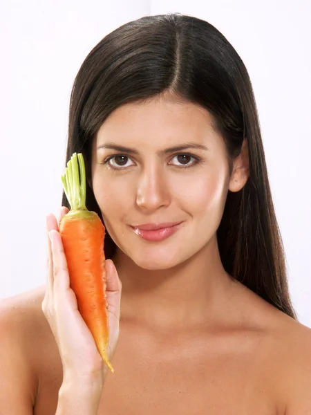 Mujer joven sosteniendo zanahorias frescas sobre fondo blanco —  Fotos de Stock