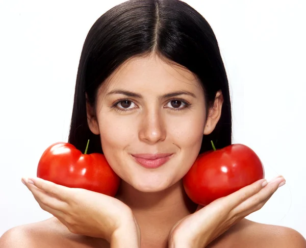 Молодая женщина держит два помидора на белом фоне — стоковое фото