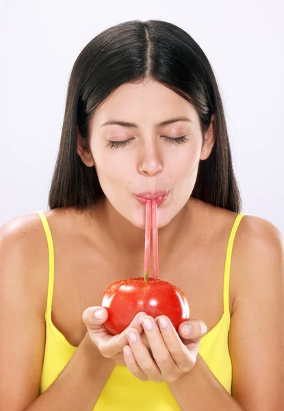 Mladá žena pití rajčatové šťávy — Stock fotografie