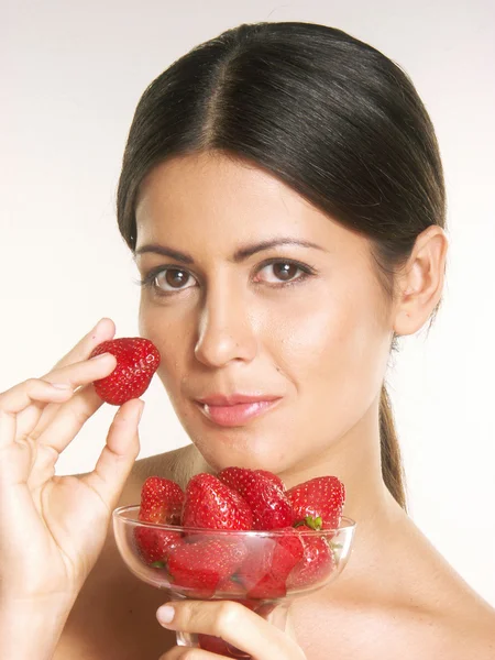 Jeune femme tenant une fraise fraîche sur fond blanc — Photo