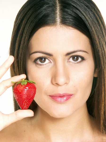 Young woman holding a fresh strawberry on white background — Stock Photo, Image