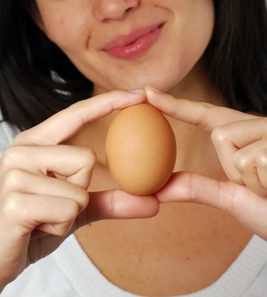 Young woman holding a fresh egg — Stock Photo, Image