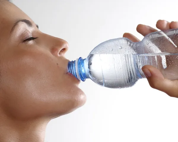 Jeune femme bouteille d'eau minérale potable — Photo