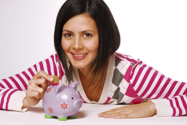 Młoda kobieta i piggy bank oszczędzania pieniędzy — Zdjęcie stockowe