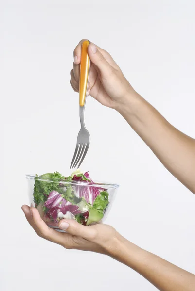 Main féminine tenant un saladier aux légumes et une fourchette — Photo