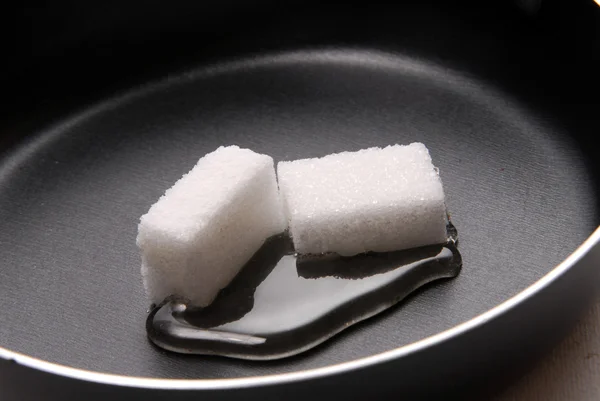 Melting sugar cubes on a hot pan — Stock Photo, Image