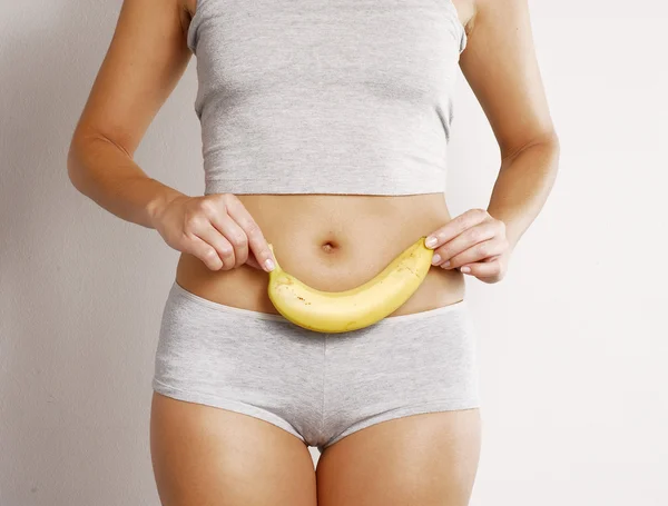 Jeune femme corps détail tenant une banane — Photo