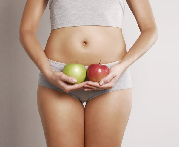 Jovem mulher corpo detalhe segurando duas maçãs — Fotografia de Stock
