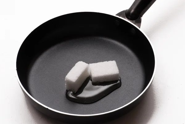 Melting sugar cubes on a pan — Stock Photo, Image