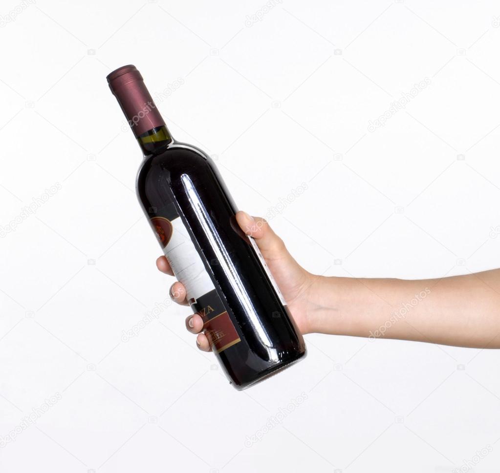 A hand holds the bottle of wine