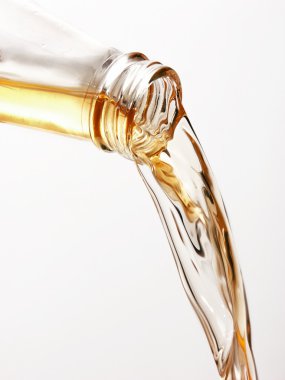 beyaz zemin üzerinde bir şişe bira döküyor